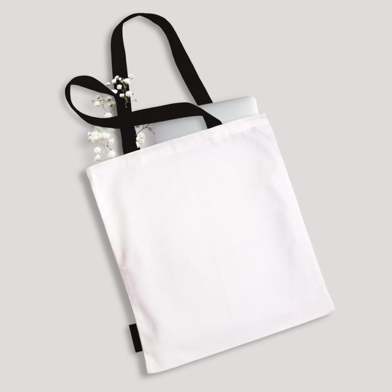 White_Blank_Cotton_Eco_Tote_Bag_With_Black_Straps_Handles_and_Little_Label_Laptop_Flowers_Inside