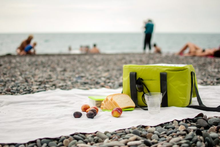 A picnic cooler bag and food on the beach